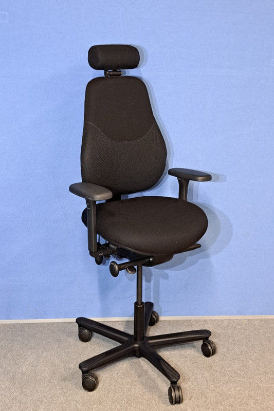 Black office chair with adjustable features against a blue wall.