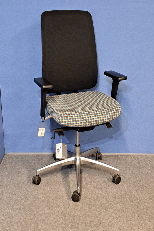 Mesh back chair with a blue floor and grey wall.