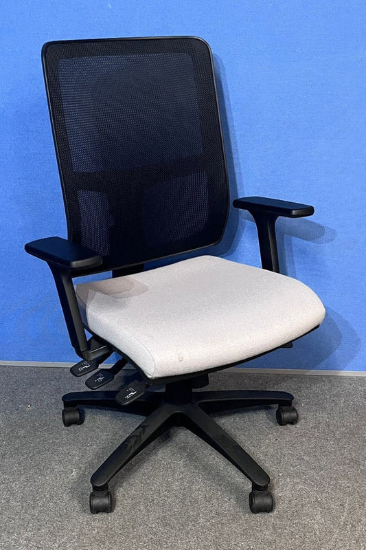 Black office chair with grey seat against a blue wall