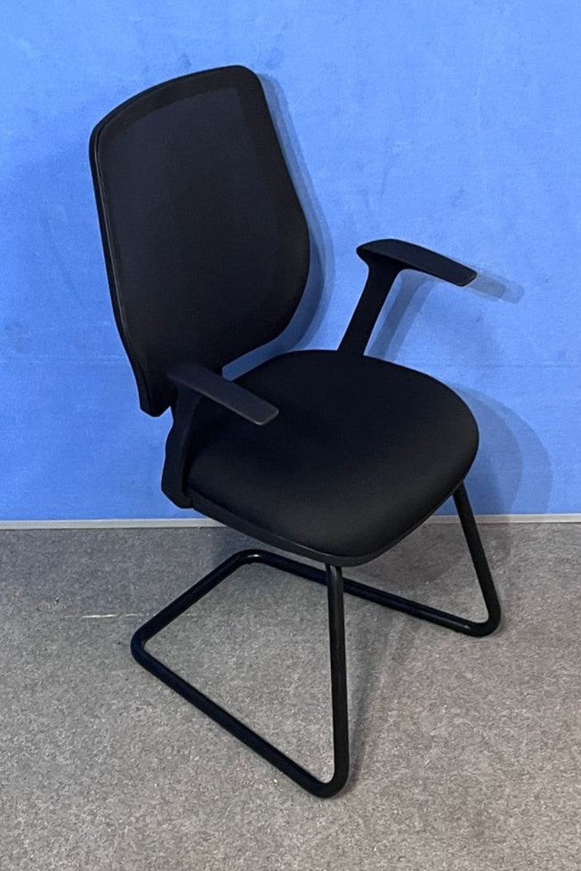 Black office chair against a blue wall