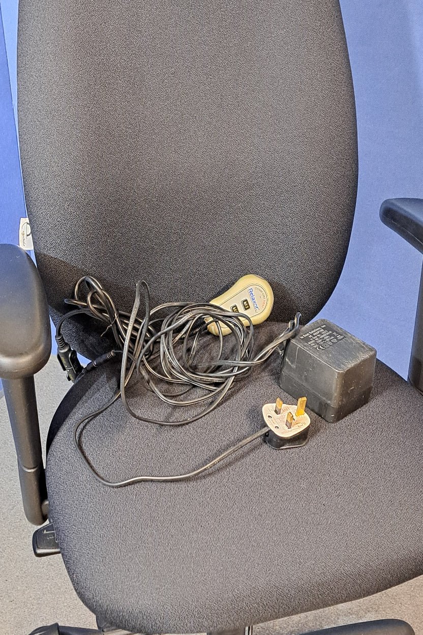 Black office chair with a power adapter and cable on a blue surface