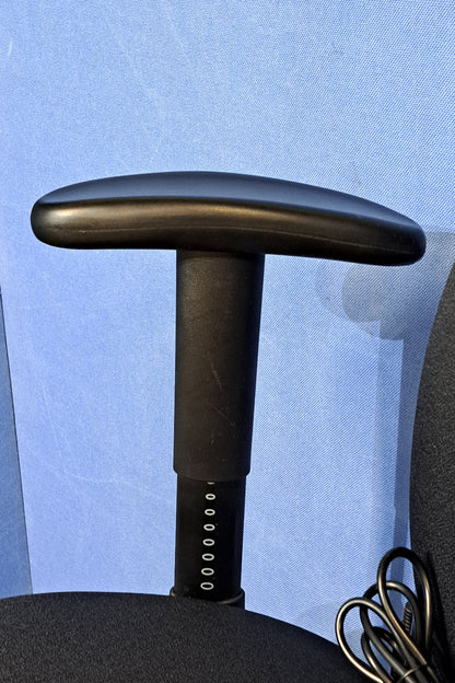 Close-up of an arm on a chair with a blue background