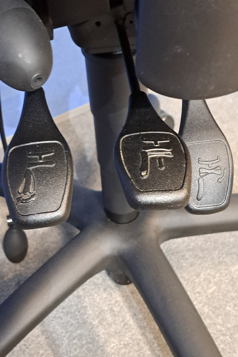 Close-up of levers on a chair with a grey and blue background