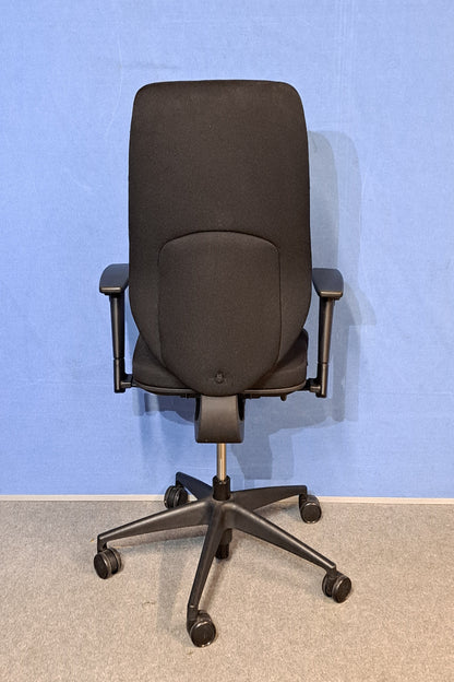 Black office chair on a blue background and grey floor