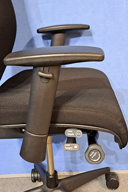 Black office chair on a blue background and grey floor
