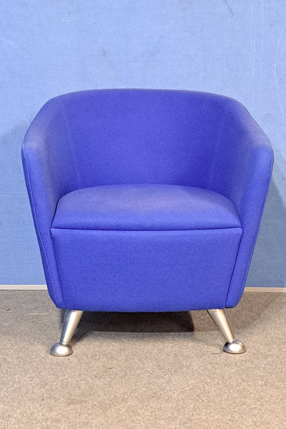 Blue chair with silver legs on a blue wall and grey floor