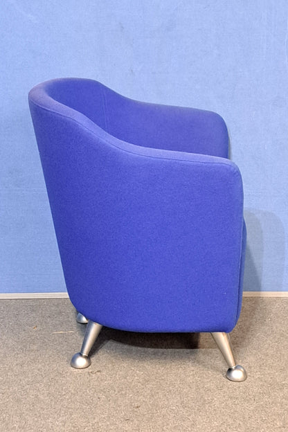 Blue chair with silver legs on a blue wall and grey floor