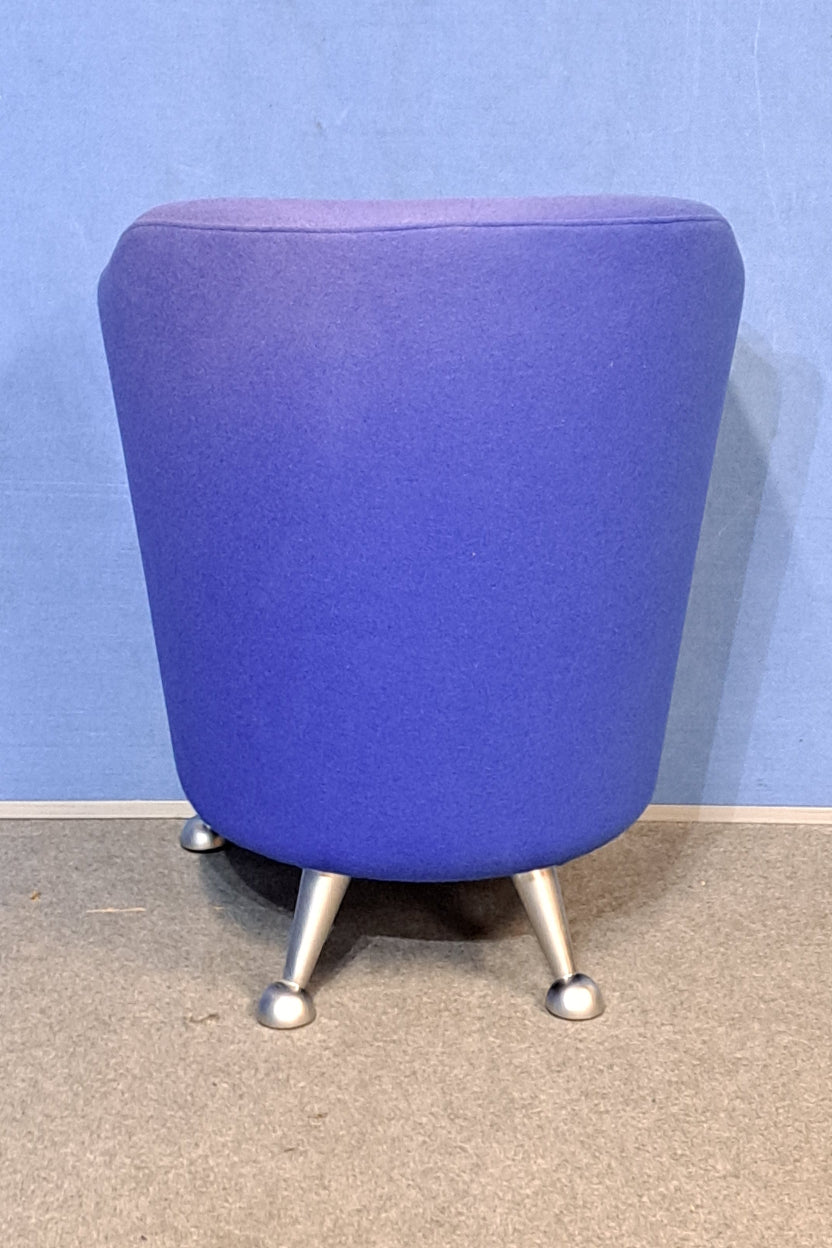 Blue chair with silver legs on a blue wall and grey floor