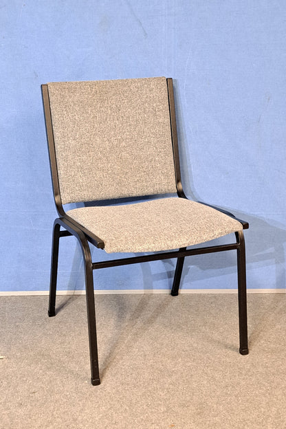 Grey meeting chair on a blue background and grey floor