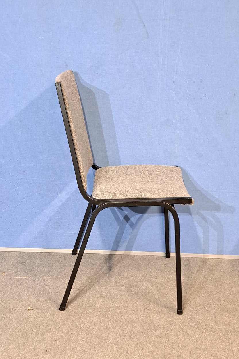 Grey meeting chair on a blue background and grey floor