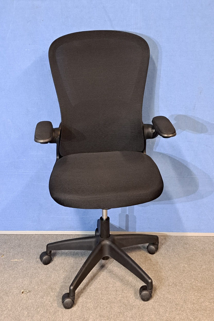 Black office chair on a blue background and grey floor
