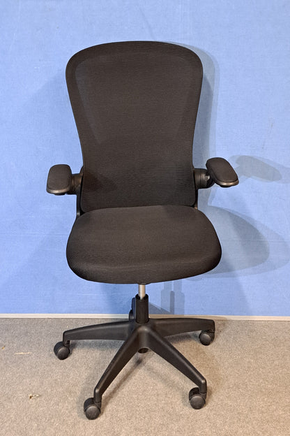 Black office chair on a blue background and grey floor