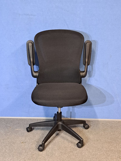 Black office chair on a blue background and grey floor
