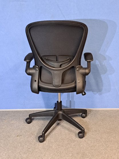Black office chair on a blue background and grey floor