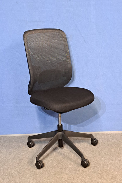 Black office chair against a blue wall and grey carpet