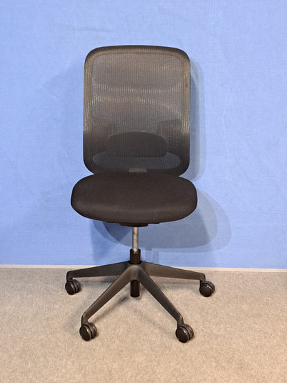 Black office chair against a blue wall and grey carpet