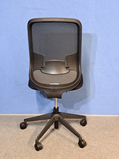 Black office chair on a blue wall and grey carpet