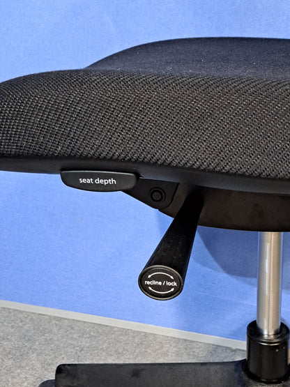 Black office chair on a blue wall and grey carpet