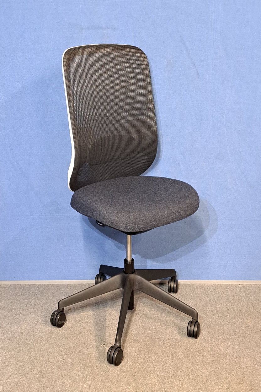 Grey / black office chair on a blue wall and grey carpet