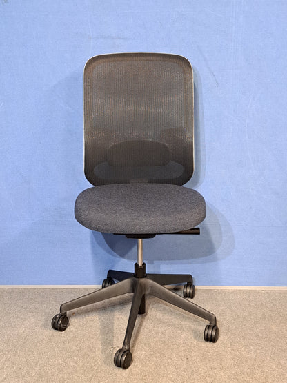 Grey / black office chair on a blue wall and grey carpet