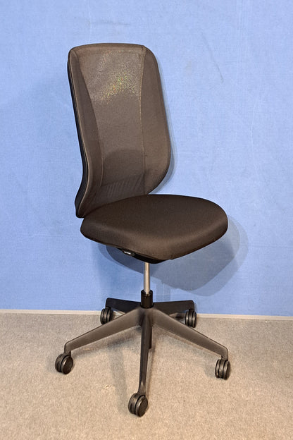 Black office chair on a blue wall and grey carpet