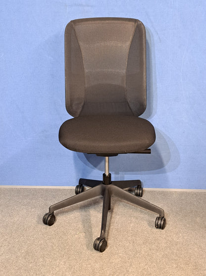 Black office chair on a blue wall and grey carpet