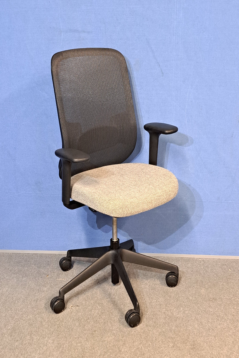 Grey office chair on a blue wall and grey carpet
