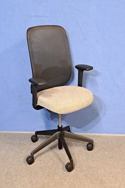 Grey office chair on a blue wall and grey carpet