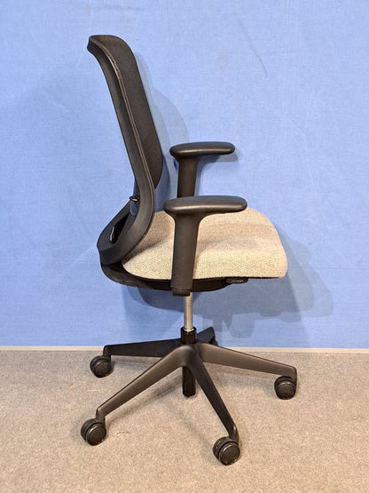 Grey office chair on a blue wall and grey carpet