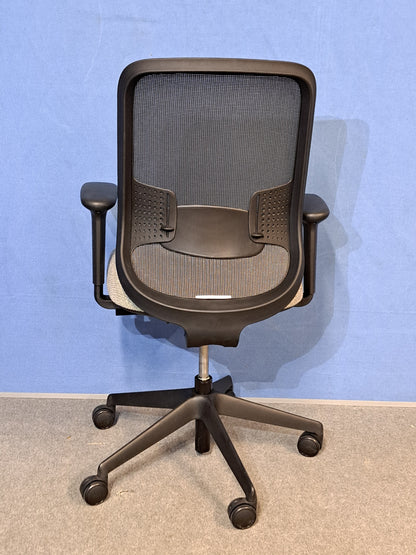 Grey office chair on a blue wall and grey carpet