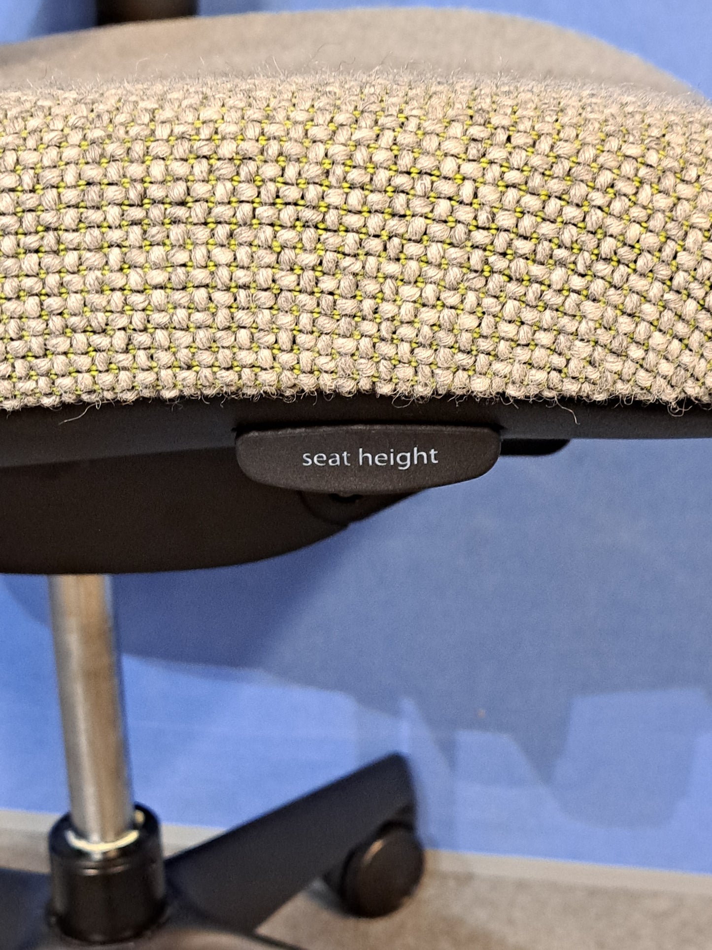 Grey office chair on a blue wall and grey carpet