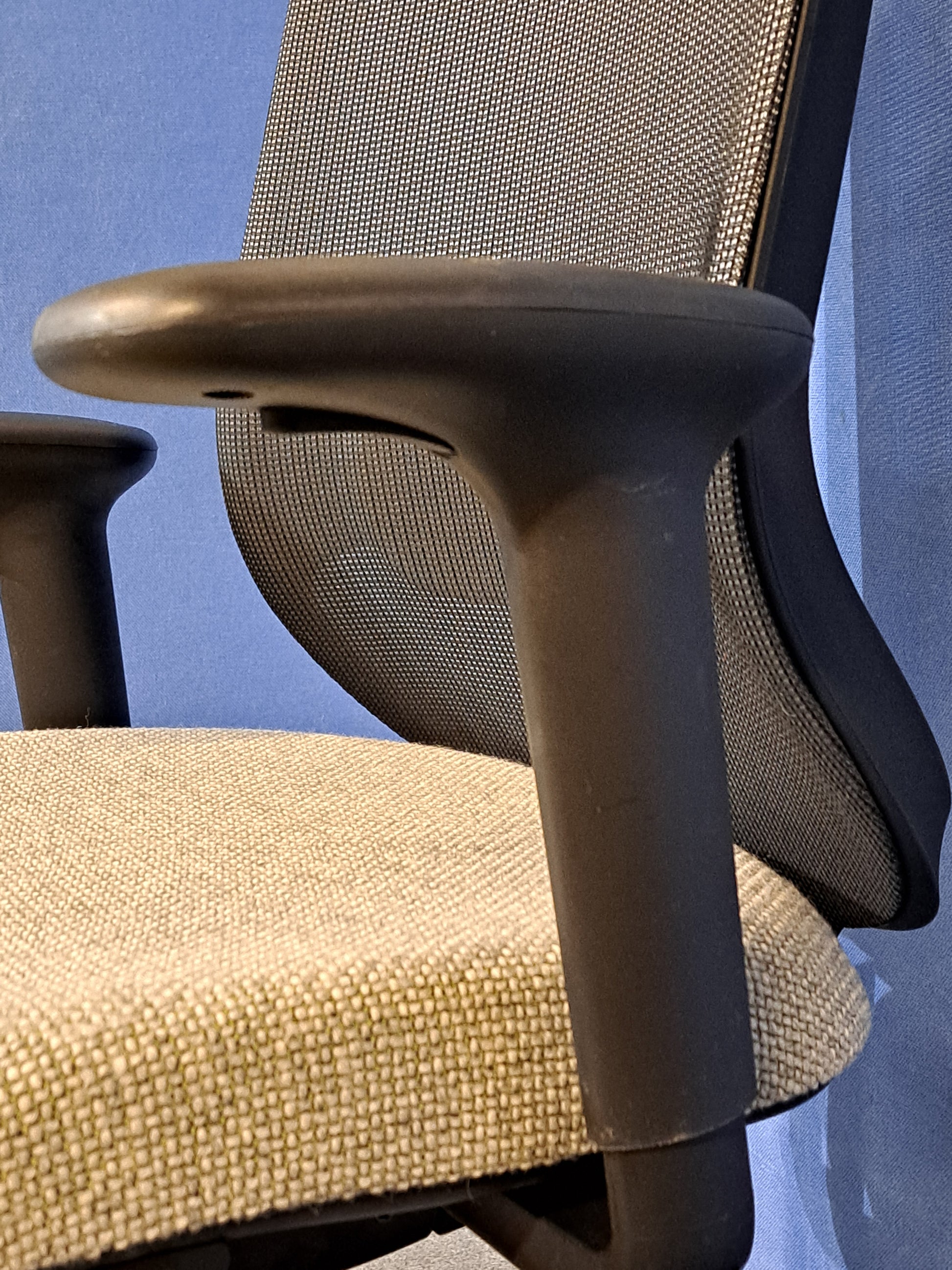 Grey office chair on a blue wall and grey carpet