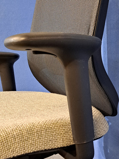 Grey office chair on a blue wall and grey carpet
