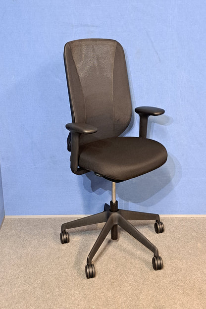 Black office chair on  blue wall and grey carpet