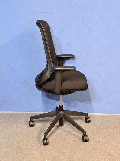 Black office chair on  blue wall and grey carpet