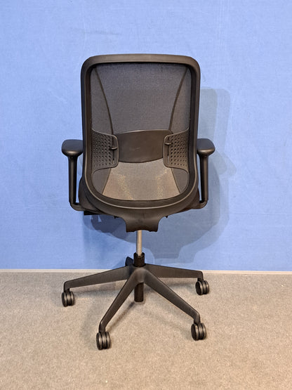 Black office chair on  blue wall and grey carpet