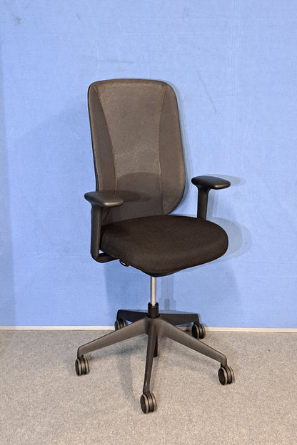 Black office chair on a blue wall and grey carpet