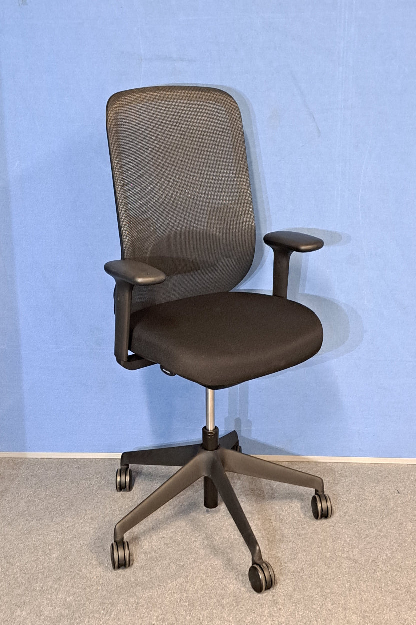 Black office chair on blue wall and grey carpet