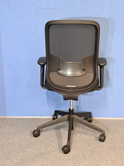 Black office chair on blue wall and grey carpet