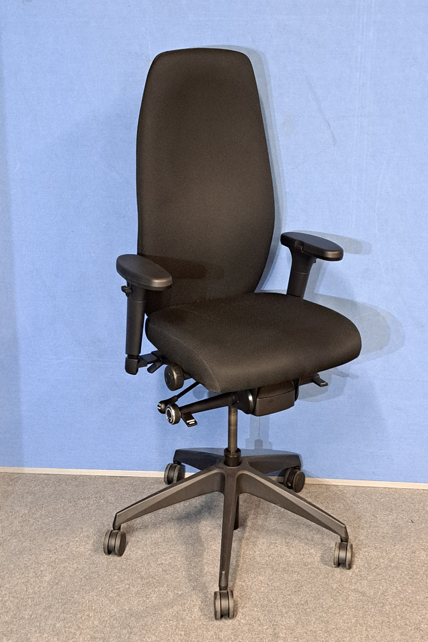 Black office chair on a blue wall and grey carpet