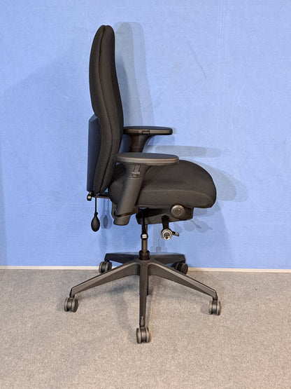 Black office chair on a blue wall and grey carpet