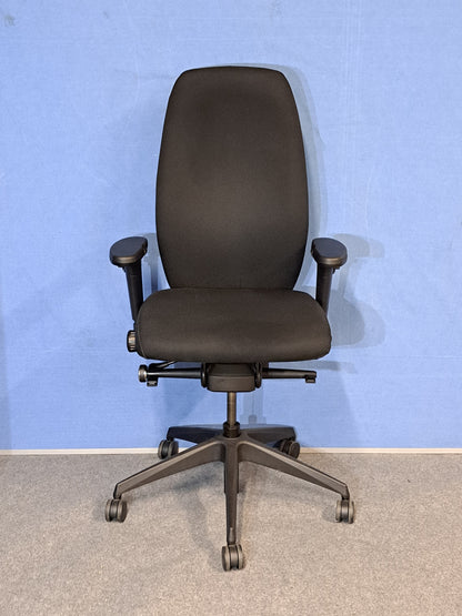 Black office chair on a blue wall and grey carpet