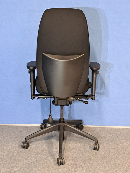 Black office chair on a blue wall and grey carpet