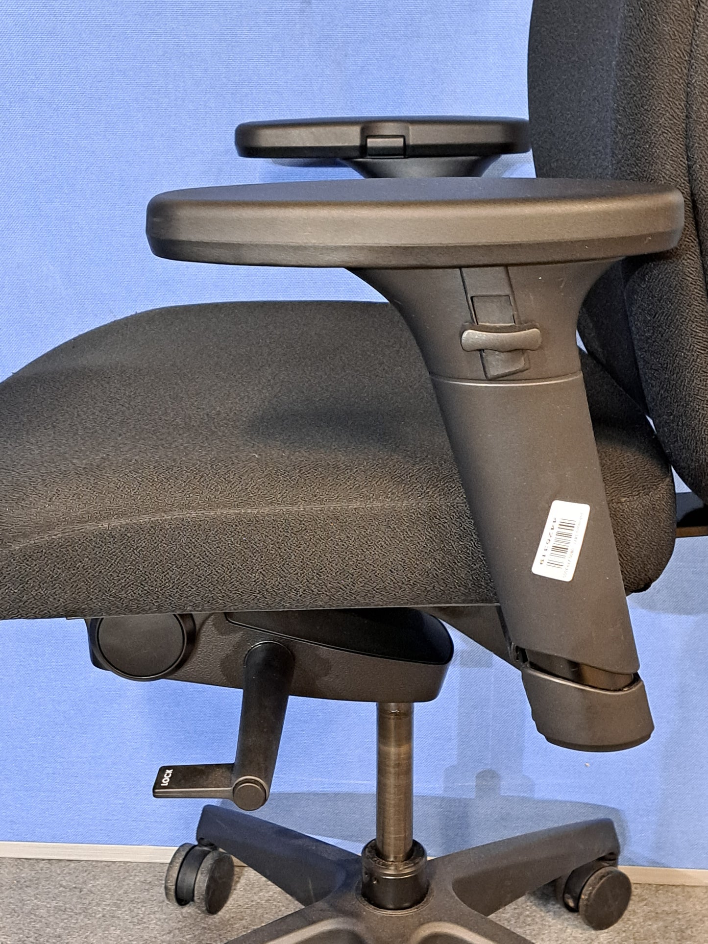 Black office chair on a blue wall and grey carpet