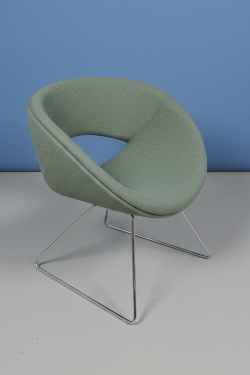 4 green chairs on a blue wall and grey floor