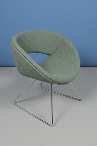 4 green chairs on a blue wall and grey floor