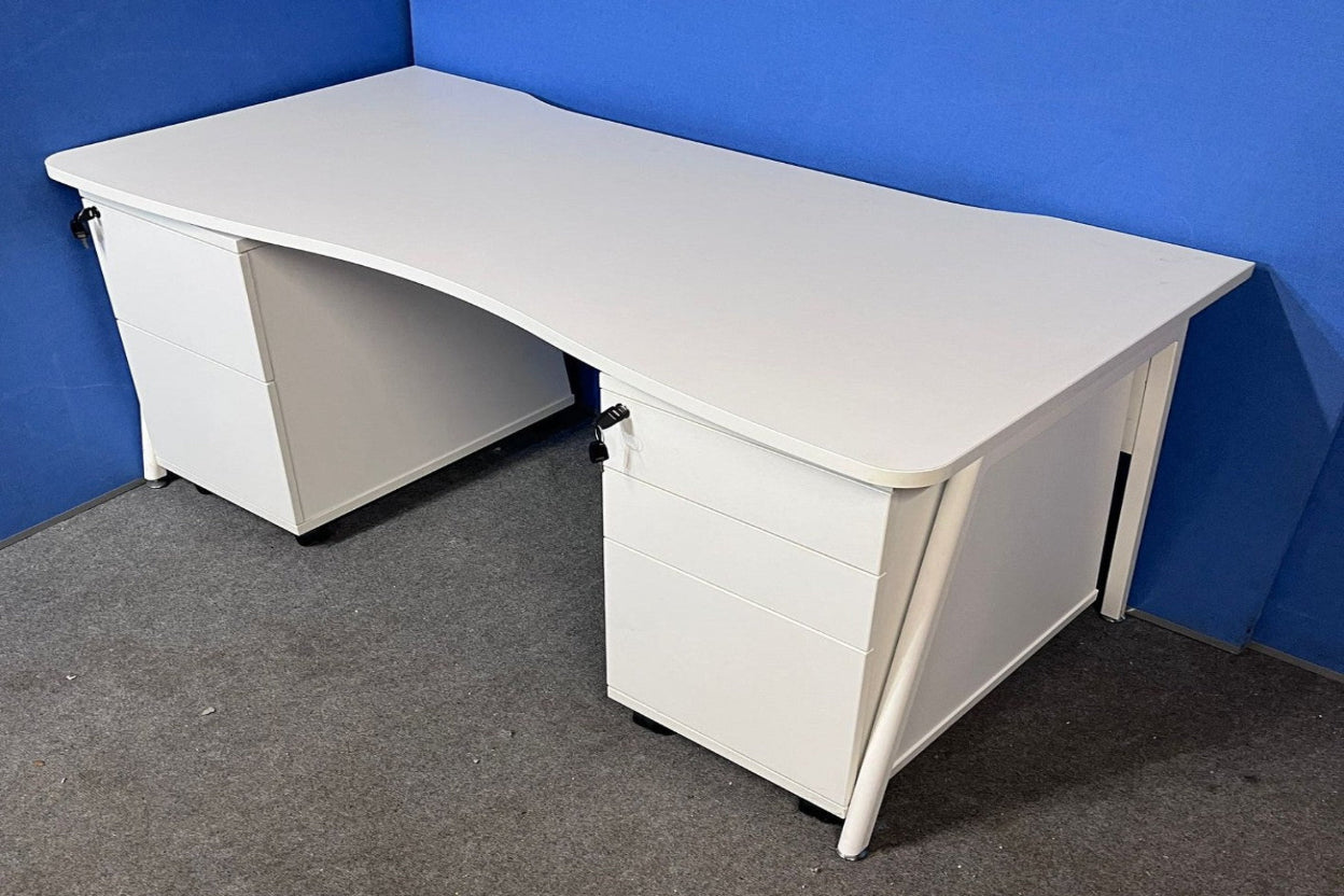 White L-shaped desk against a blue wall