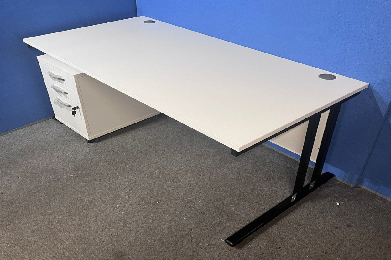 White office desk with black legs against a blue wall.