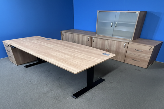 Wooden office desk with cabinets against a blue wall