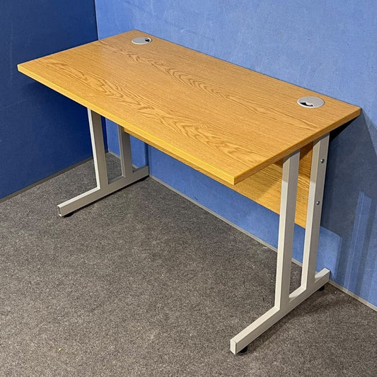 Oak straight desk on a blue wall and grey carpet
